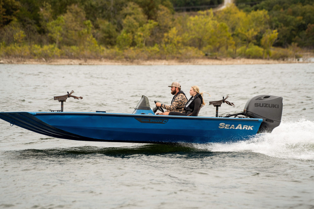 SeaArk Shadow 18 — manufacturer photo, running along a tree-lined shoreline